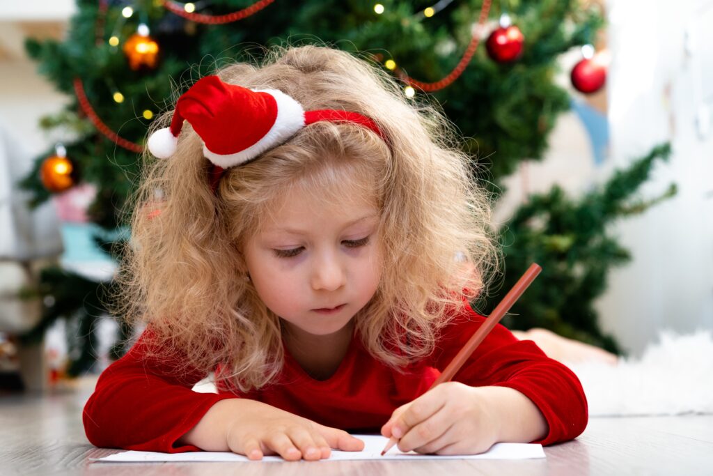 Kleines mädchen malt ein Bild für den Weihanchtsmann